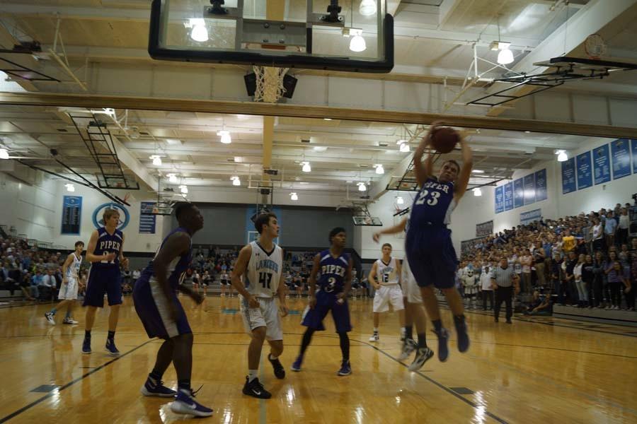 Senior Collin Beebe rips a rebound from a Shawnee Mission East defender, the Pirates’ came up short losing 56-40.