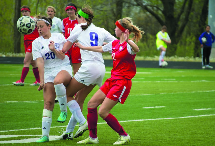 Junior Jami Gooch, sophomore Emily Wilson and a Bishop Miege player get involved in a collision for the ball. Wilson soon came out of this with the ball taking it toward the Pirates goal.