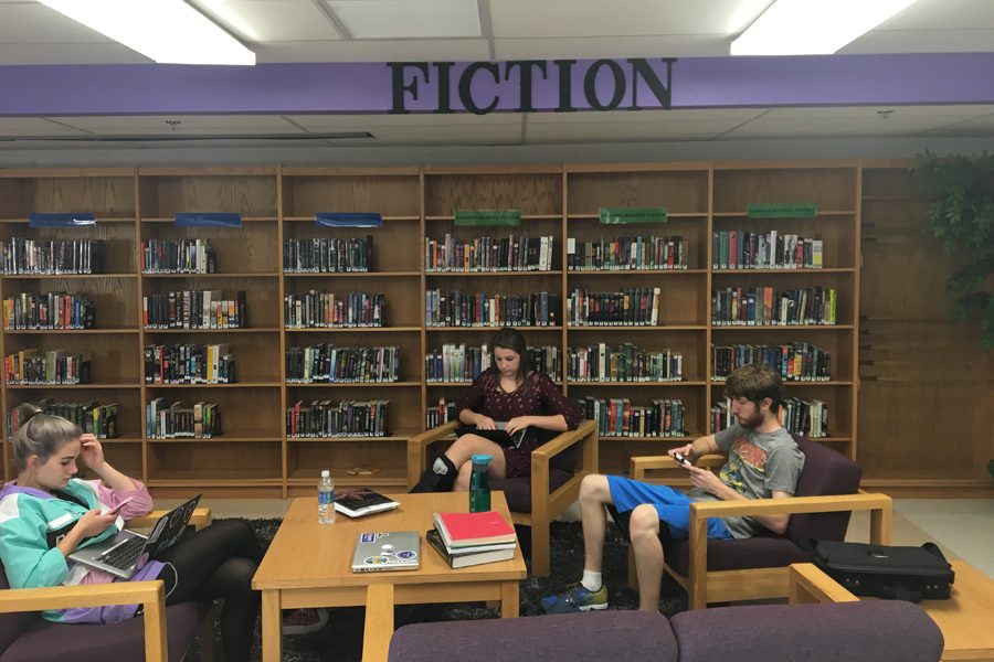 Seniors Jalen Zwart, Katie Sullivan and Chase Giese work near the fiction section of the library. Although this furniture is not new, the club is planning on replacing all library furniture.