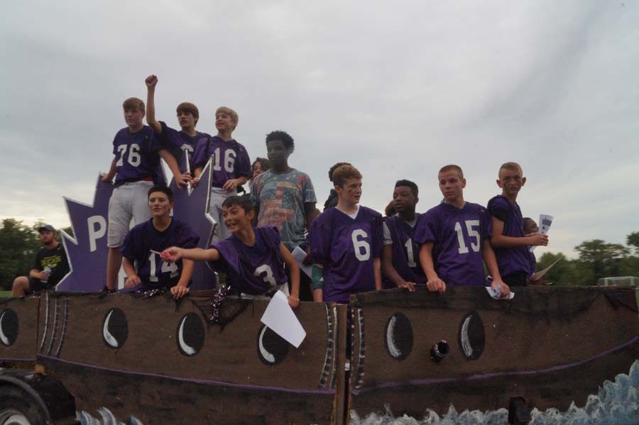 The younger football players go by in a interesting float looking forward to the game.