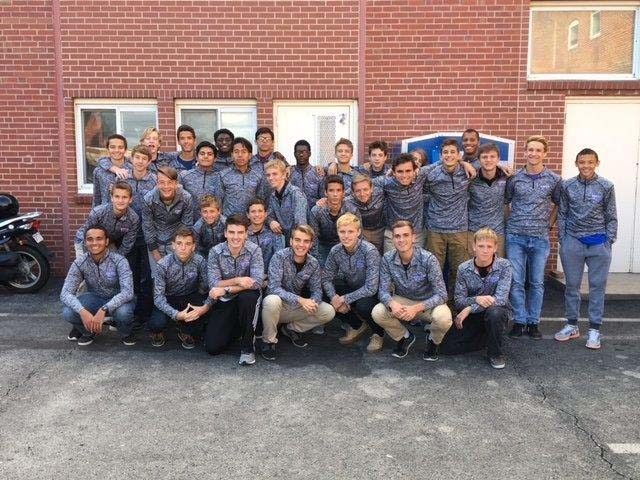 The boys soccer team poses for a picture wearing their new uniform jackets.