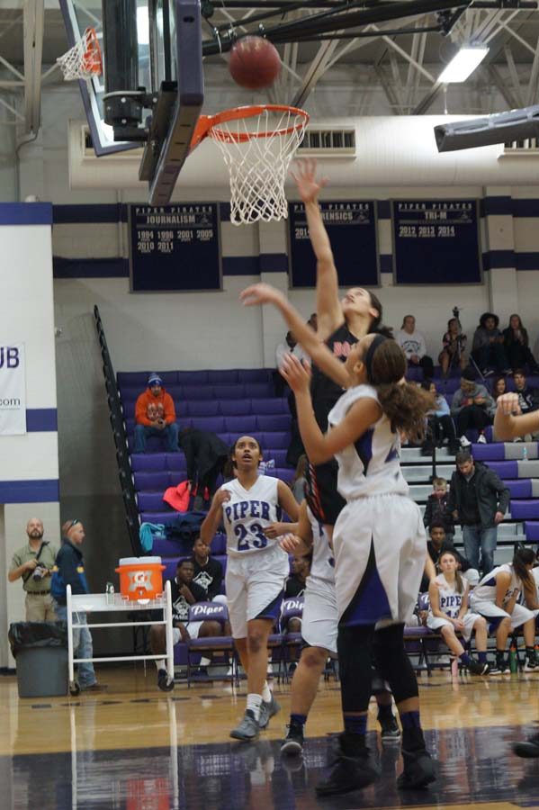 Sophomore, LaKya Leslie goes for the shot in the second half of the girls varsity game with Sophomore, Ryan Cobbins coming in to help with the rebound.