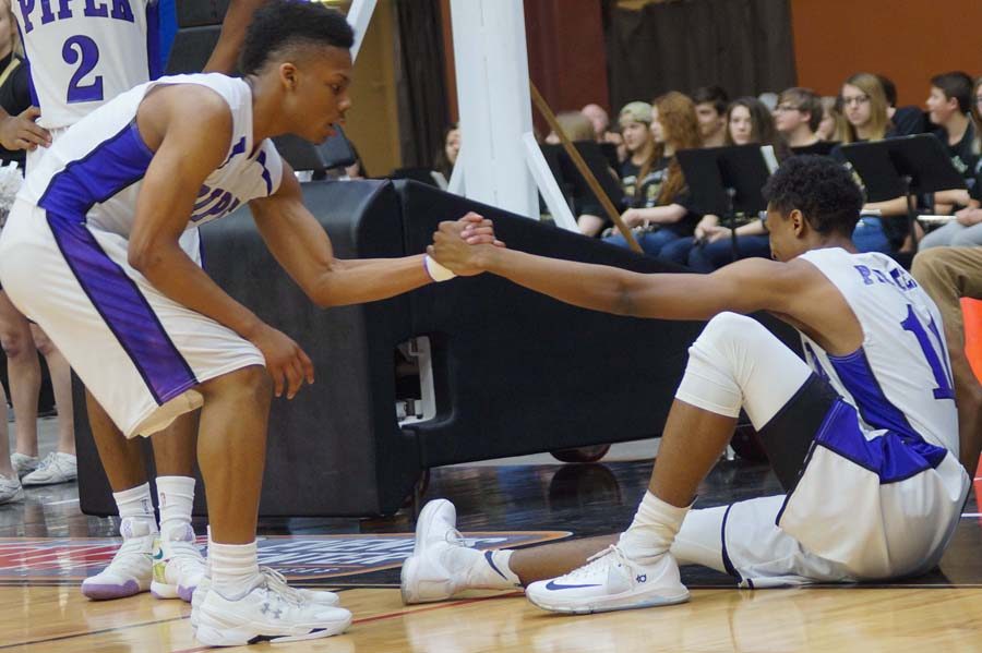 Junior Doc Covington helps senior Jalen Taylor off the floor after Taylor was fouled and tweaked an ankle. Taylor grimaced through the free throws, but remained in the game.
