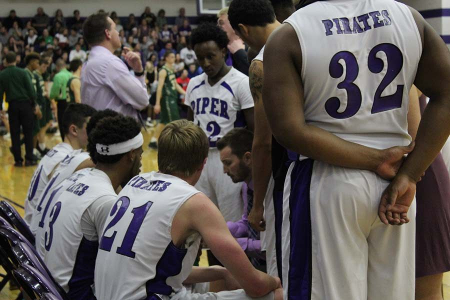 Senior Demond Tallie and the rest of the Pirates listen as head coach Bryan Shelley diagrams late-game strategy in the fourth quarter.