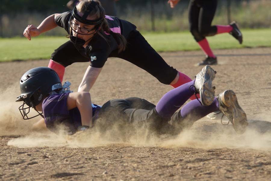 Freshman Bella Gravatt dives back to the bag from a throwdown from the Lansing catcher.  She dodges the glove and is safe.  She scores off an RBI double by freshman Emma Martin in the first inning. 