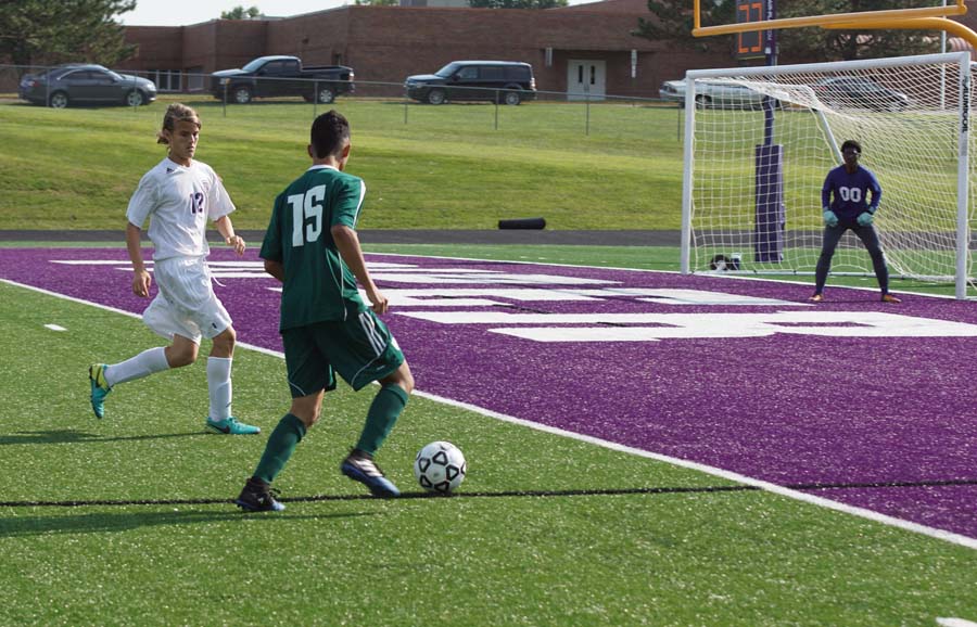 JV player #12 looks to take the ball away from a De Soto player looking for a shot. Sophomore keeper Miles Lockridge gets ready to defend the goal in the meantime.