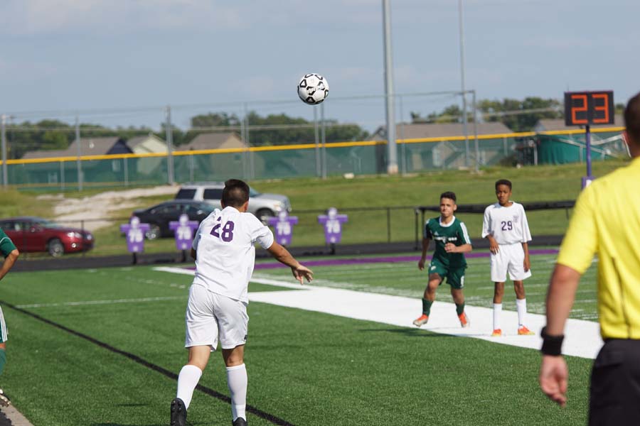 In the JV soccer game against De Soto High School, Pipers #28 throws the ball back in the game in the direction of his teammate #29.