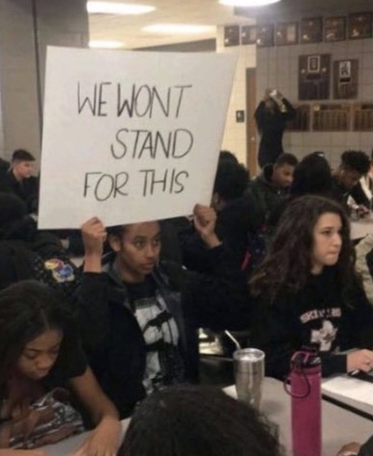 Junior+Ryan+Cobbins+holds+up+a+sign+reading+we+wont+stand+for+this+at+the+protest+Dec.+15.