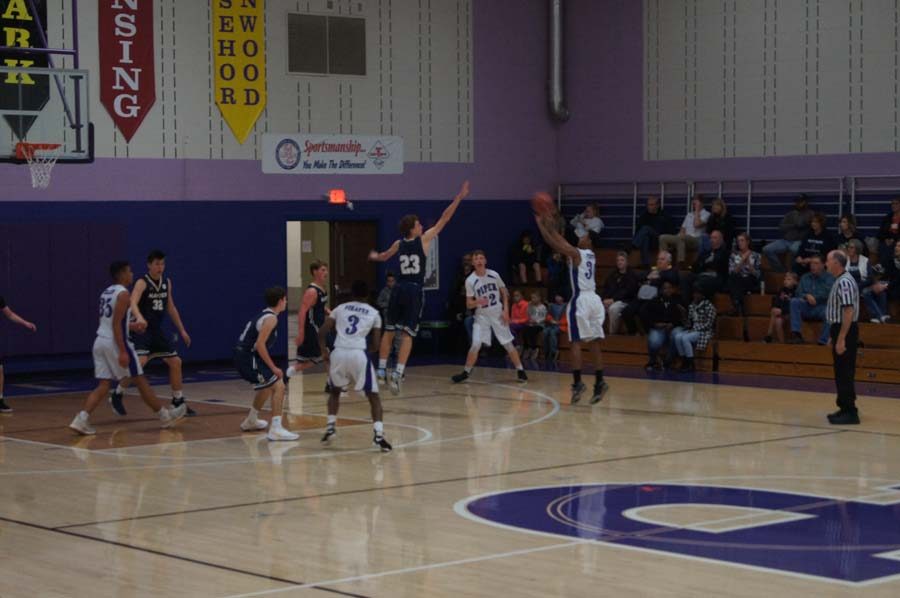 Junior Elijah Hooks shoots a contested three-pointer in the JV game against Topeka-Hayden.