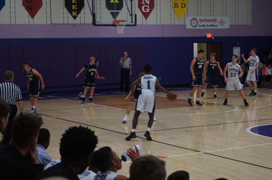 Sophomore Terrence Collins scans the court to find an open teammate against Topeka-Hayden  Dec. 12. 