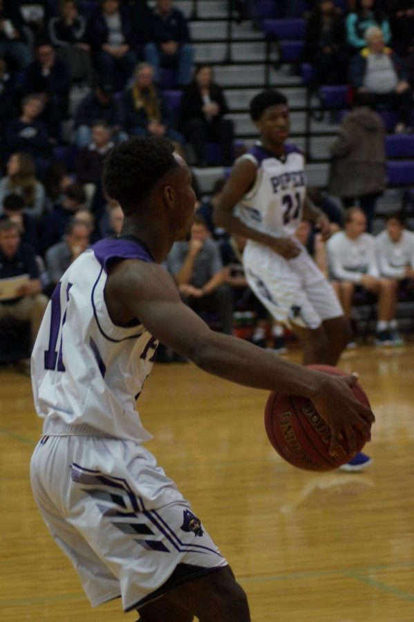Junior Tyrone Bates, "Tricky Tre" brings the ball down the court against their opponents Topeka Hayden on December 12, 2017. 