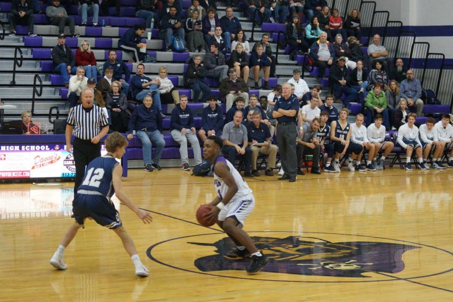 Junior Trey Bates dribbles pass the defender.