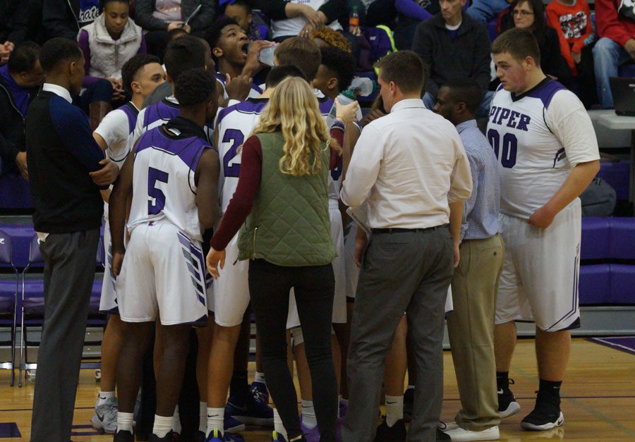 Senior manager Emma Golden hands out water battles during a timeout during the Topeka Hayden basketball game. 