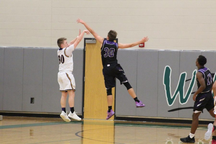 Senior Bryce Yoder jumps to block and defend a shot.