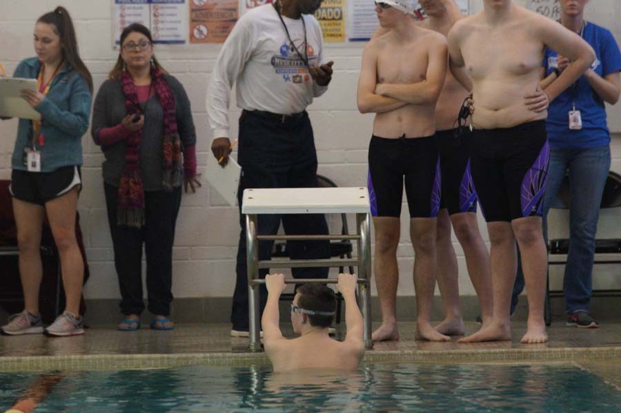 Junior Chase Bundy in the water getting ready to swim backstroke in the 200 medley relay. 