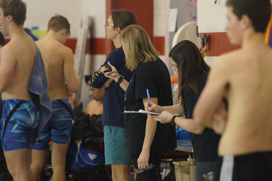 Coach Bartlow times the swimmers while Coach Meeker writes down the times at the swim meet at Washington High School. 