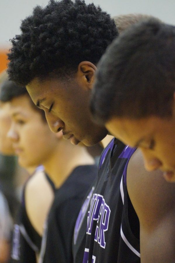 Junior Brandan Jackson bows his head during the national anthem to prepare for the game against the Bonner Braves Jan. 12.