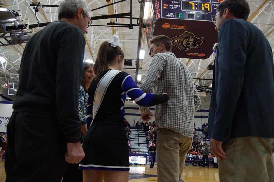 Senior Gabe Dandar takes Sophia Fricks arm to accompany her to their spot on the court.