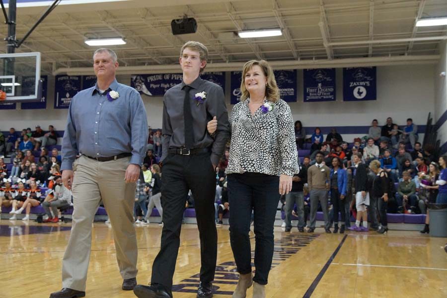 Senior Drake Martin is accompanied by his parents before walking with Aubree Knetter to await the rest of the nominees.