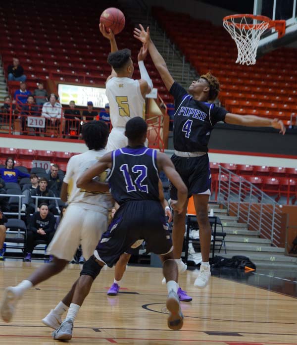 Junior Braijion Barnes jumps to block the incoming shot from Andover Central in the first half of the state game March 8.