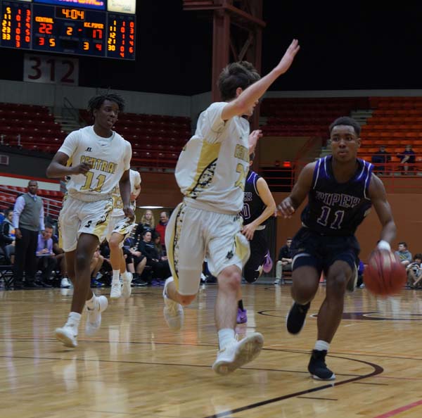 Junior Trey Bates drives down the court for a lay up in the second quarter of the March 8 game against Andover Central.