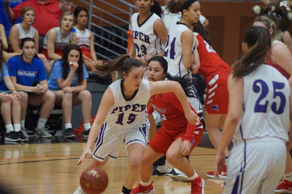 Sophomore Grace Banes dribbles through the opposing team making it closer to the basket to score.