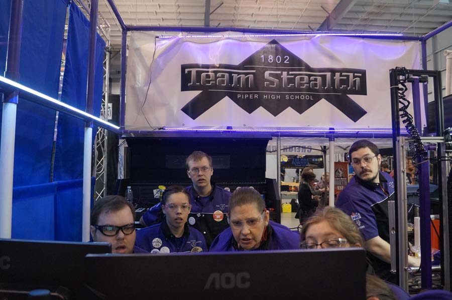 The team watches as the scores for the rounds come in. With a huge score coming across the screen the team all stares in admiration.