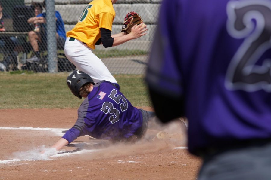 Sophomore Brendyn Bard slides into home to secure another run for the pirates as the awaiting batter Colton Lloyd watches