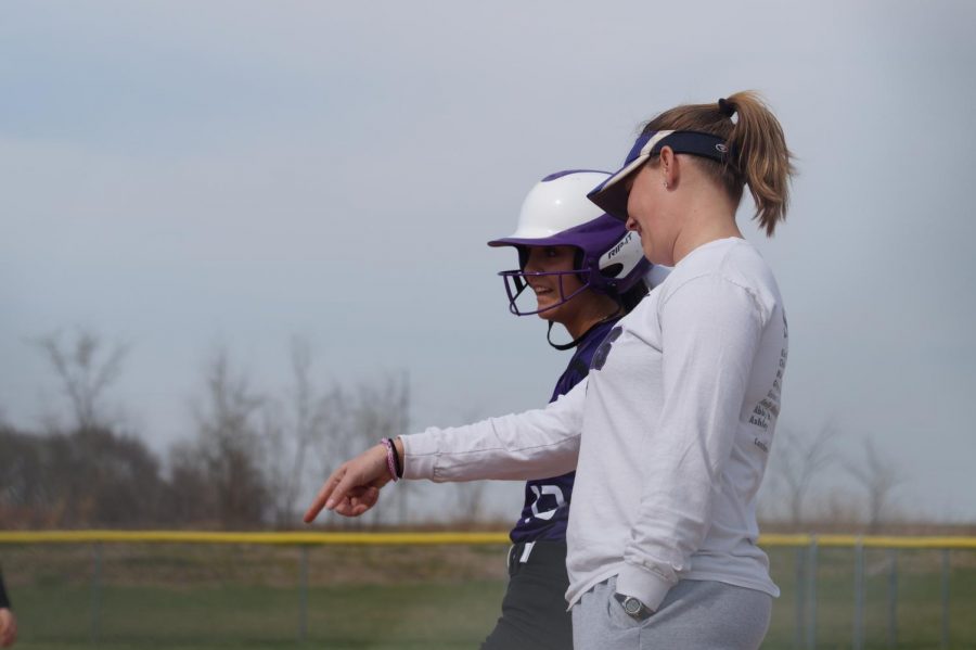 Senior Alexis Rhymer talks to coach Angie Mullins after she secures first base