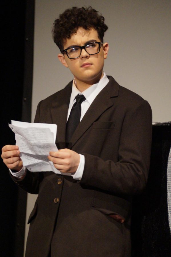 Sophomore Trent Smith playing one of the radium companies managers looks in curiosity at one of the other characters.