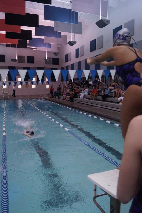 Sophomore Kaylin Miller gets ready to dive off of the block for the 200 freestyle relay as junior Taran Kerst swims in.