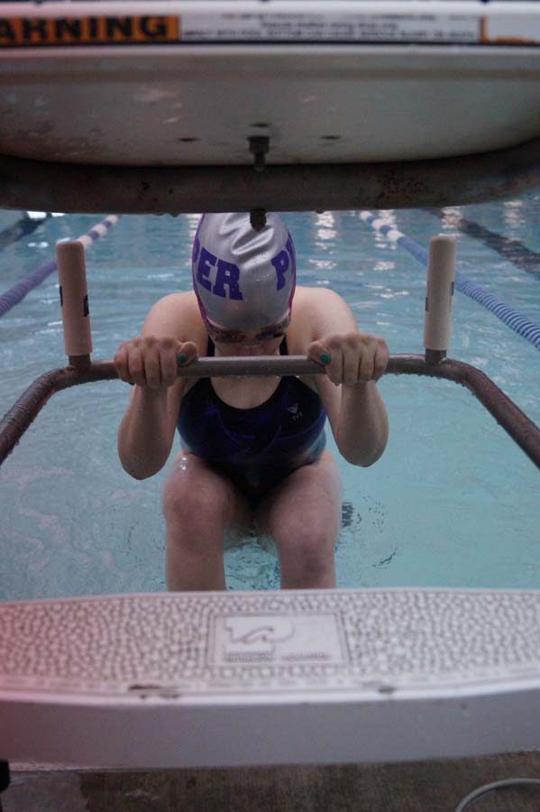 Sophomore Courtney Johnson places her feet as she gets ready to swim 100 backstroke.