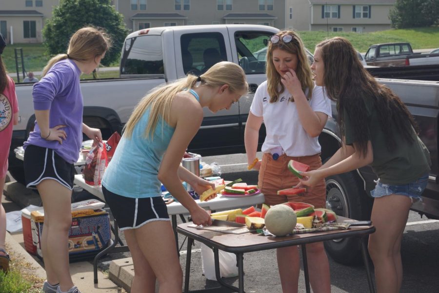 Seniors Elle Blake, Madison Wright, Grace Vogel, and Zoey Zager cut fruit for the cookout.