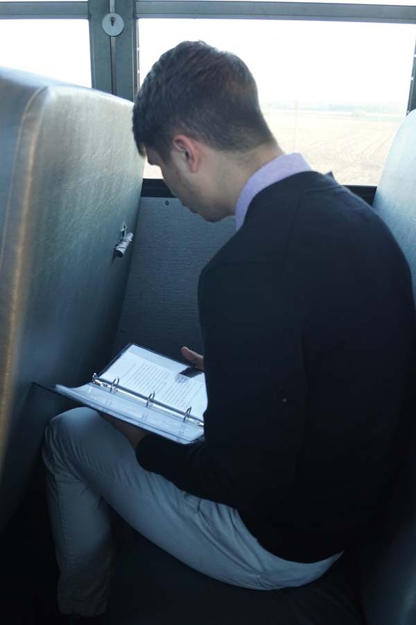 Senior Isaia Wilcoxen, rehearses his prose piece on the bus ride to Washburn Rural for state forensics. 