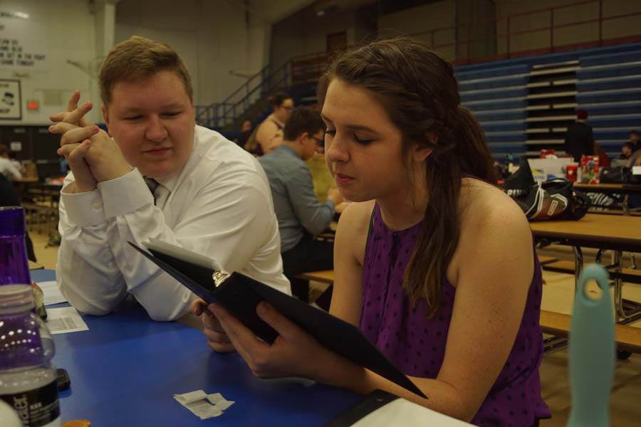 Senior Scott Ladish listens to senior Jessica Hutchings rehearse her poetry piece before her second round at state forensics.