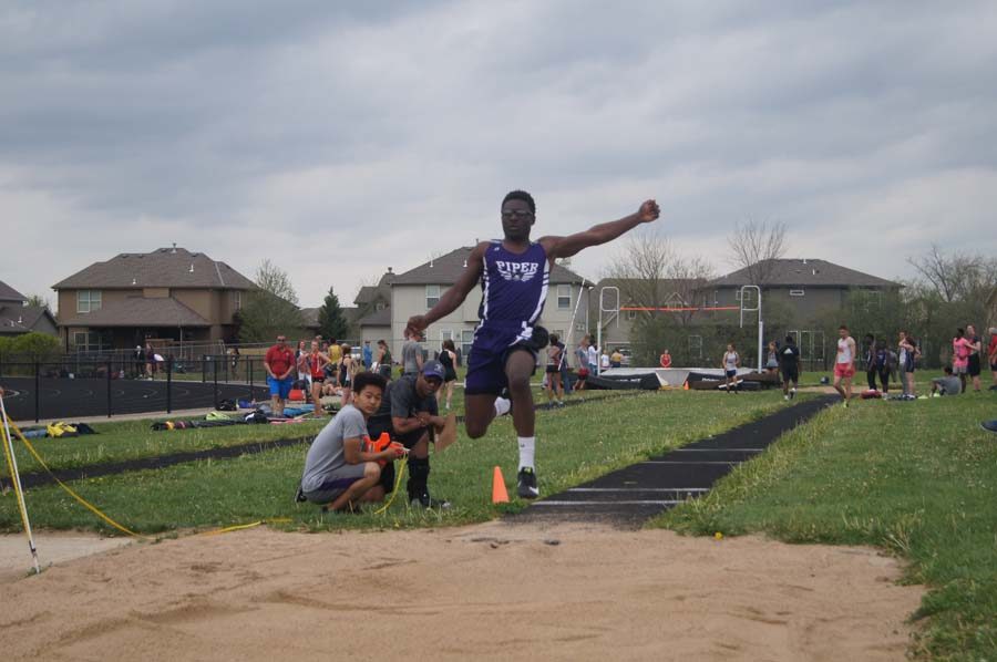 Freshman Anthony Fergus lands his third jump as the judge watches.