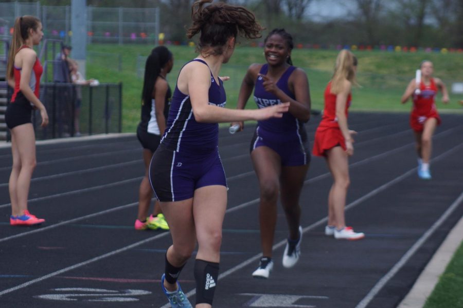 Freshman Jennifer Guilbeaux pulls through her 400 passing the baton to junior Marisa Sanchez.