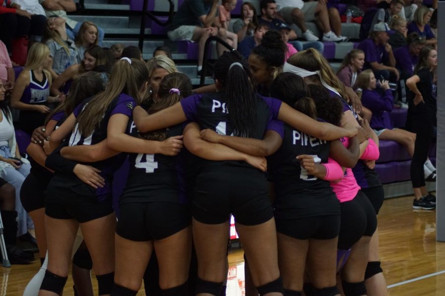 The varisty volleyball squad huddles up during a timeout by Coach Swatek. 