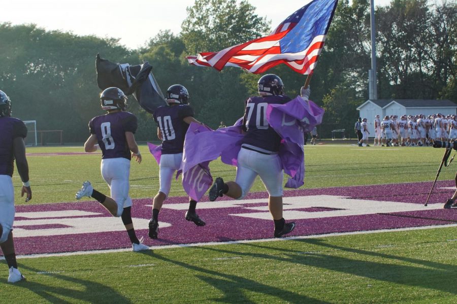 The Pirates charge the field before the game, and are being led by seniors Dalton White and Cooper Beebe.