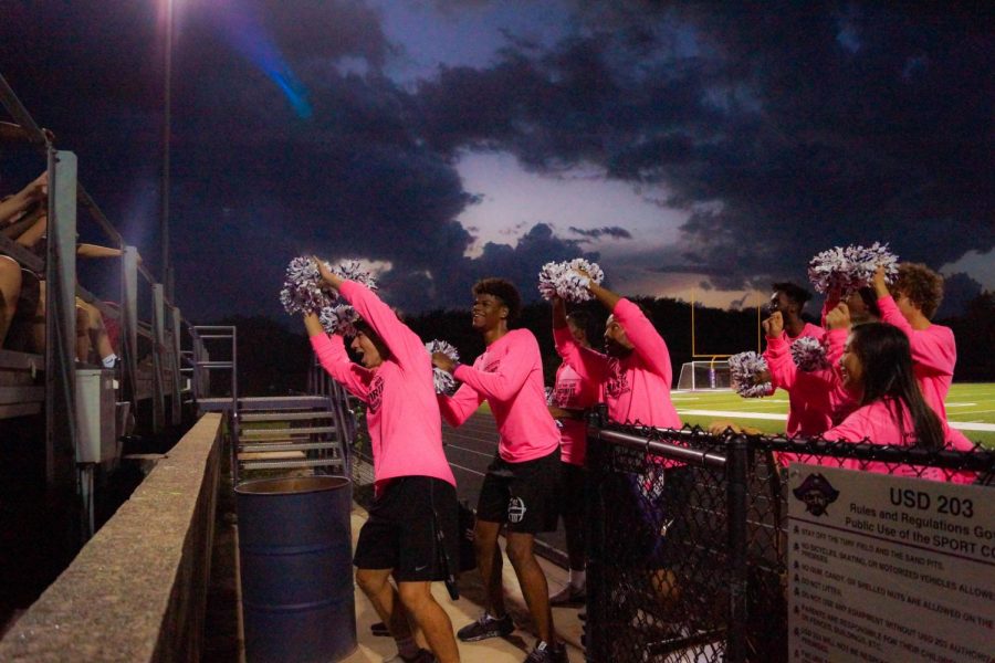 Seniors Dalton White, Braijion Barnes, and the other powder puff cheerleaders lead the Pirates' student section in the roller coaster chant. 
