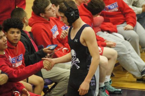 Junior Tyson Lanter for boys varsity wrestling, shakes the hand of his opponent after his match. Lanter surprised the Miege team by walking over to them to shake hands with his opponent.