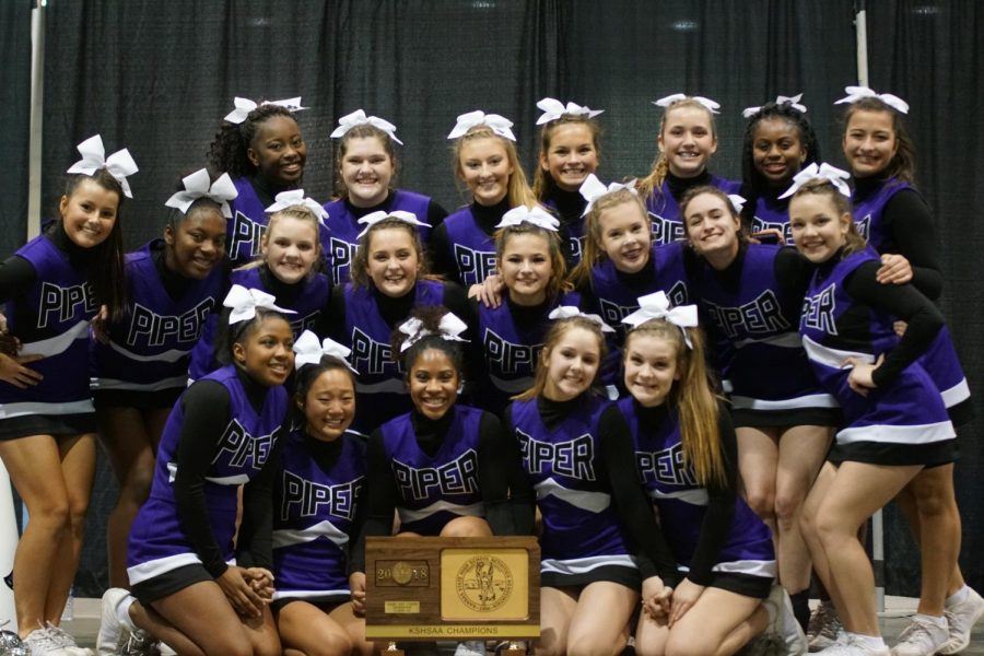 Cheer team celebrates State Game Day Competition win with trophy.