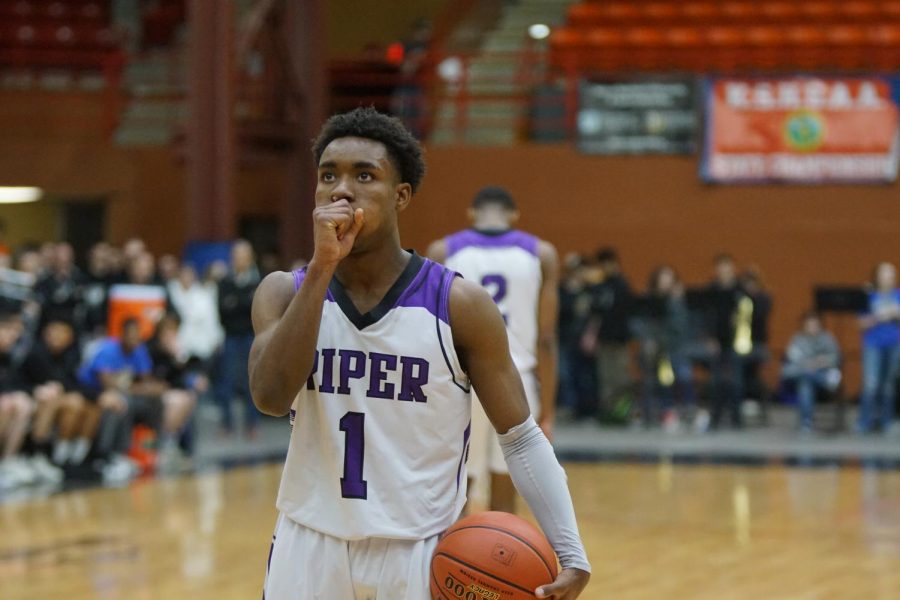 Senior Trey Bates goes through his free throw routine as sophomore brother Tamar Bates prepares for defense.