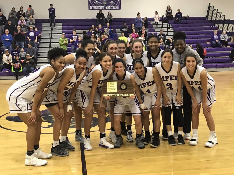 The Lady Pirates pose with sub-state trophy after defeating Chanute.