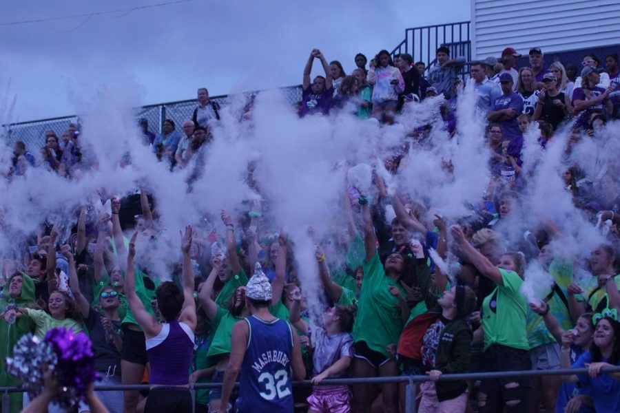 Student section throws powder before the Homecoming football game.
