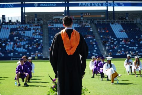 Graduates walk the stage at socially distanced graduation nearly three months later than planned