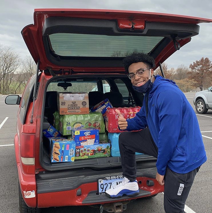 Senior Arrick Taylor poses in front of trunk full of snacks for Pirates Bay.