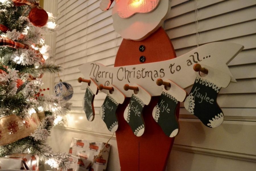 Junior Kaylee Schutte takes time with her family during a busy finals week to help put up christmas decorations and relax. This decoration in particular has had a spot in Schutte's home for 16 years. It is Schutte's favorite decoration, because "It includes her family and Santa Claus," Schutte says. Photo By Kaylee Schutte.