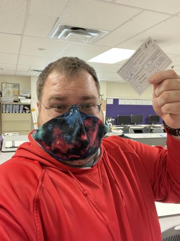 High School teacher Stephan Brumbaugh poses with vaccination card which shows receipt of receiving the COVID-19 vaccine. 