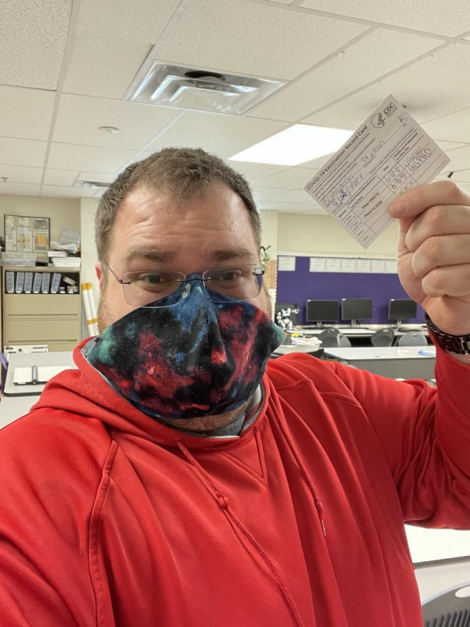 High School teacher Stephan Brumbaugh poses with vaccination card which shows receipt of receiving the COVID-19 vaccine. 